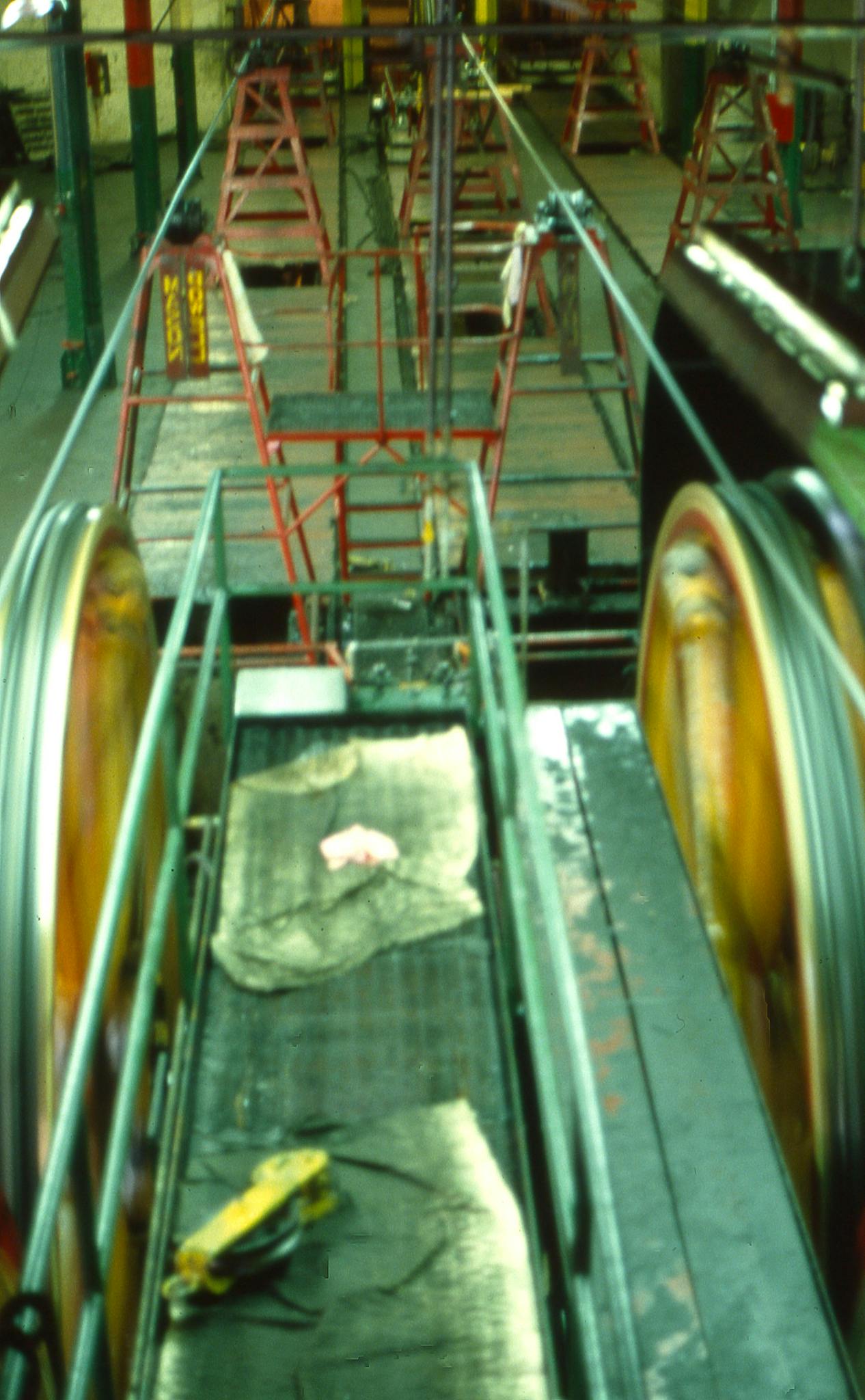 Photo by Malcolm Hill Close-up view of an industrial conveyor belt in a factory setting.