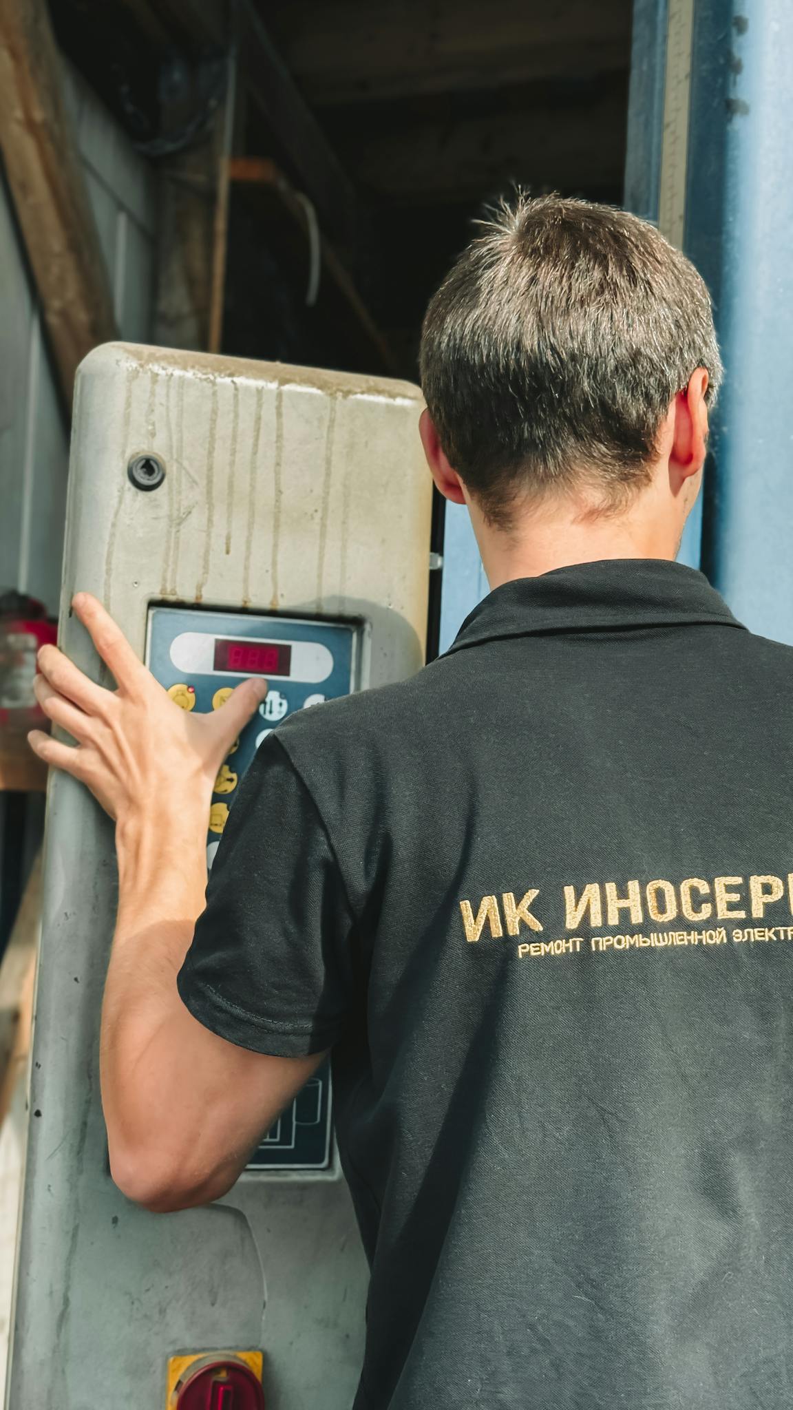 Photo by Bulat369 🌙 Industrial technician examining control panel, ensuring operational efficiency in a workshop.